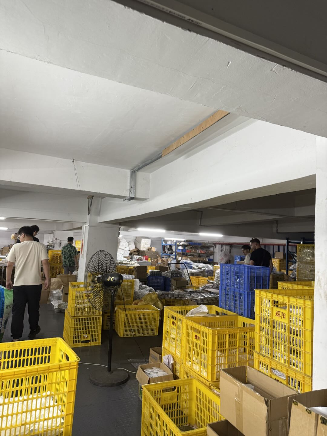 Armazém da operação com mercadoria em caixas e cestos de separação, aguardando conferência