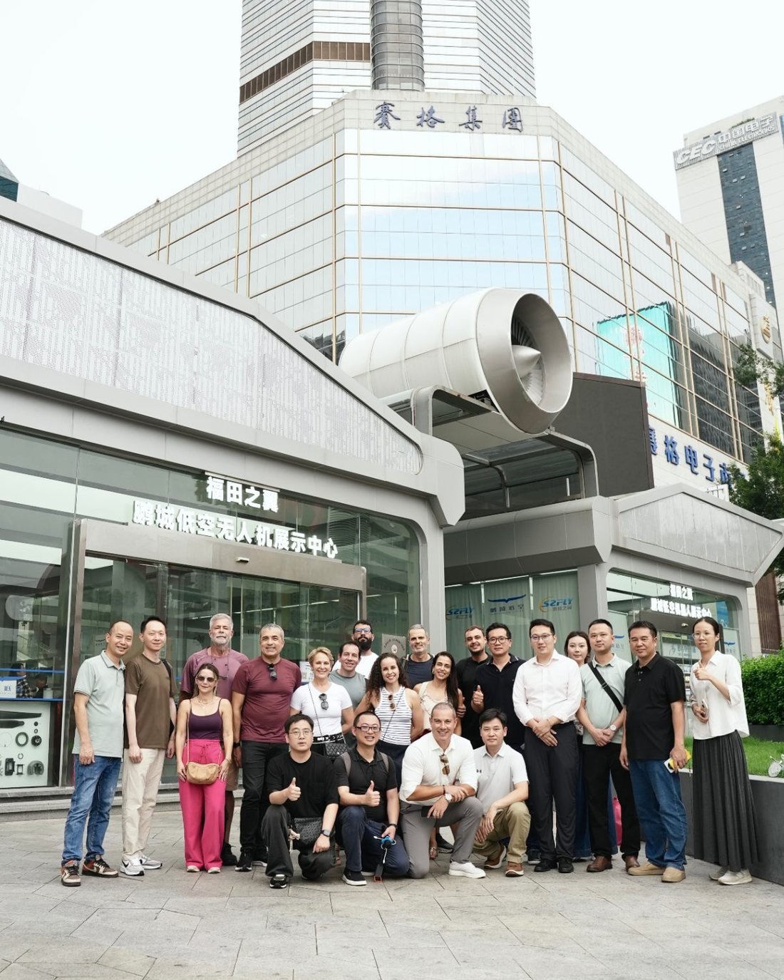 Equipe e clientes reunidos em frente à fachada do Shenzhen SEG Electronics Market